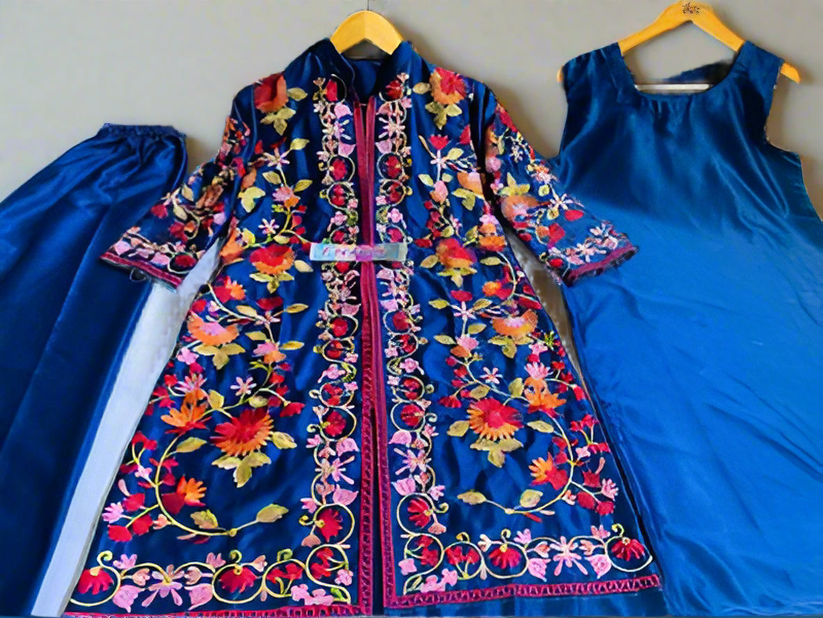 Colorful embroidered dress on a hanger with a plain blue dress beside it.