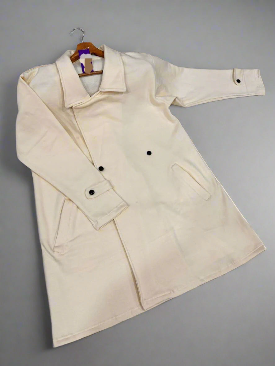 Beige coat on a hanger against a gray background
