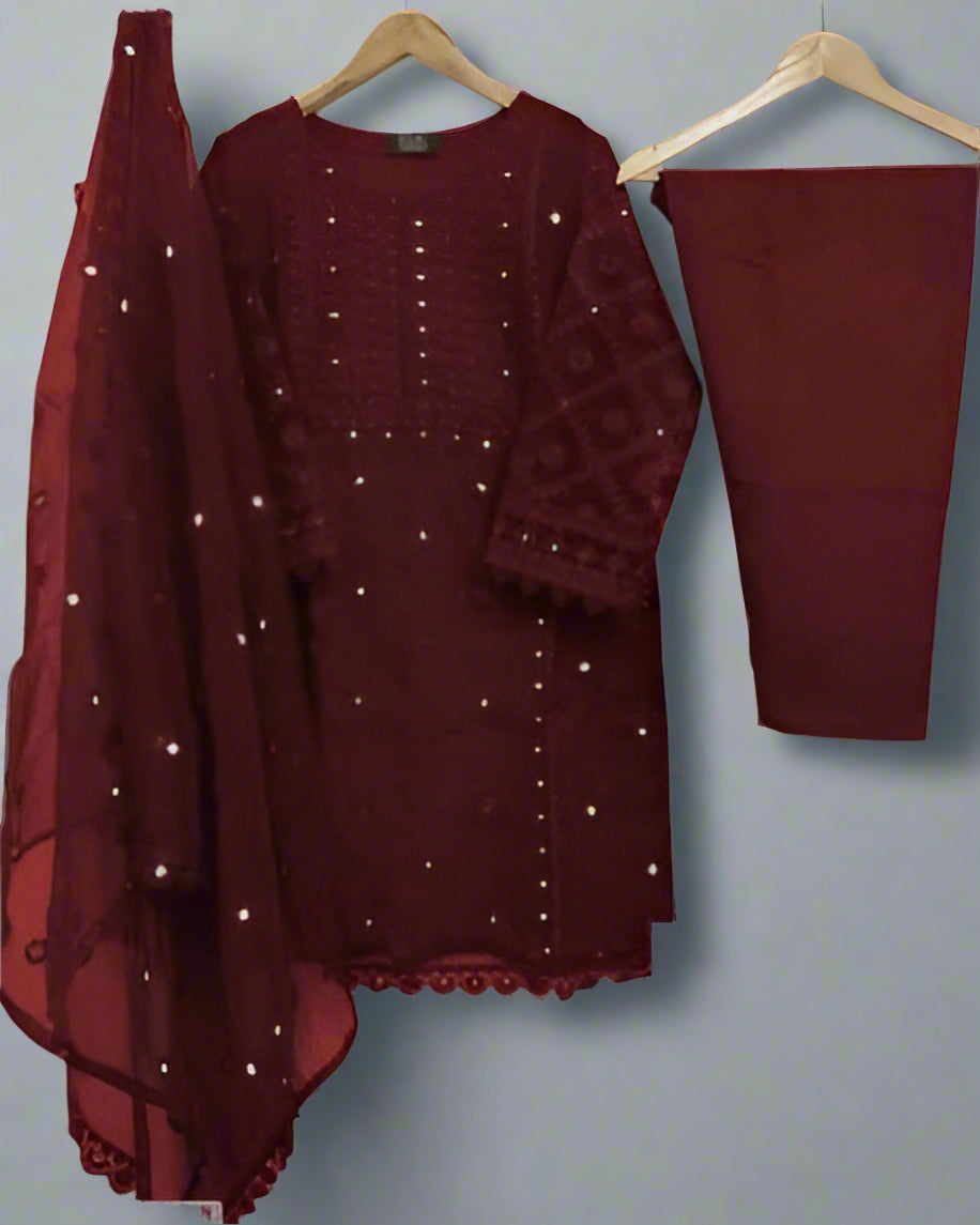Maroon traditional outfit with dupatta on hangers against a gray wall
