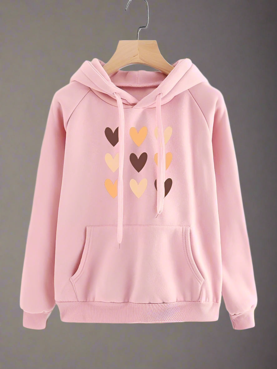 Pink hoodie with heart designs on a beige background