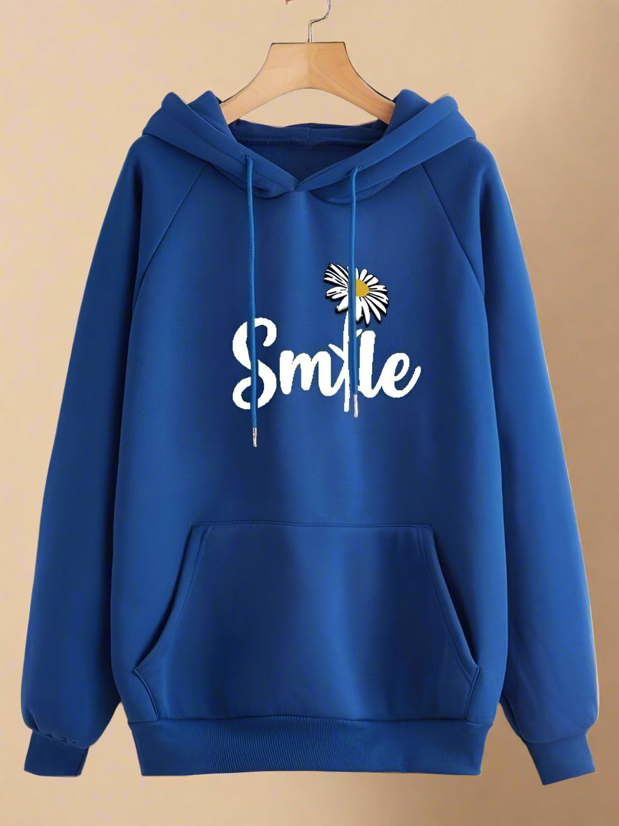 Blue hoodie with 'Smile' and flower design on a hanger against a beige background
