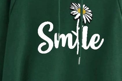 Green sweatshirt with 'Smile' and a daisy design on a plain background