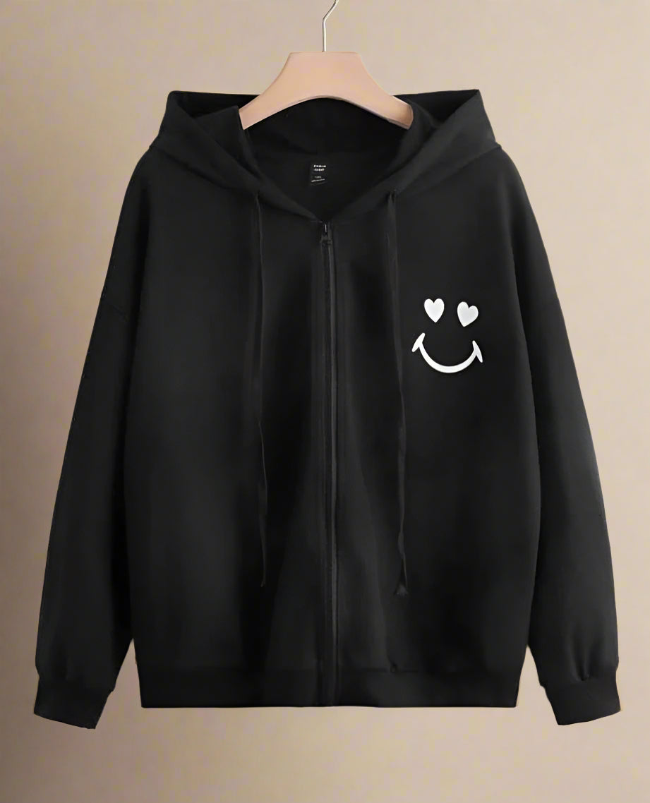 Black hoodie with a smiley face design on a beige background