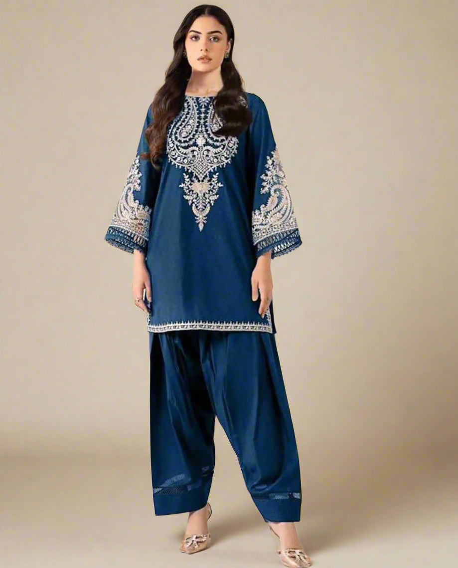 Woman wearing a blue embroidered outfit with Maria B branding on a beige background