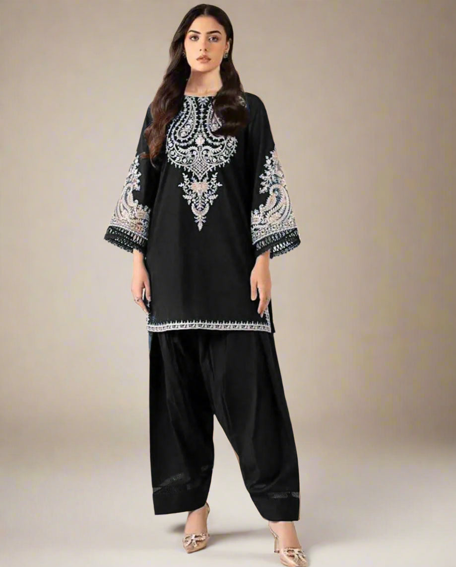 Woman wearing a black embroidered outfit with Maria B branding on a beige background