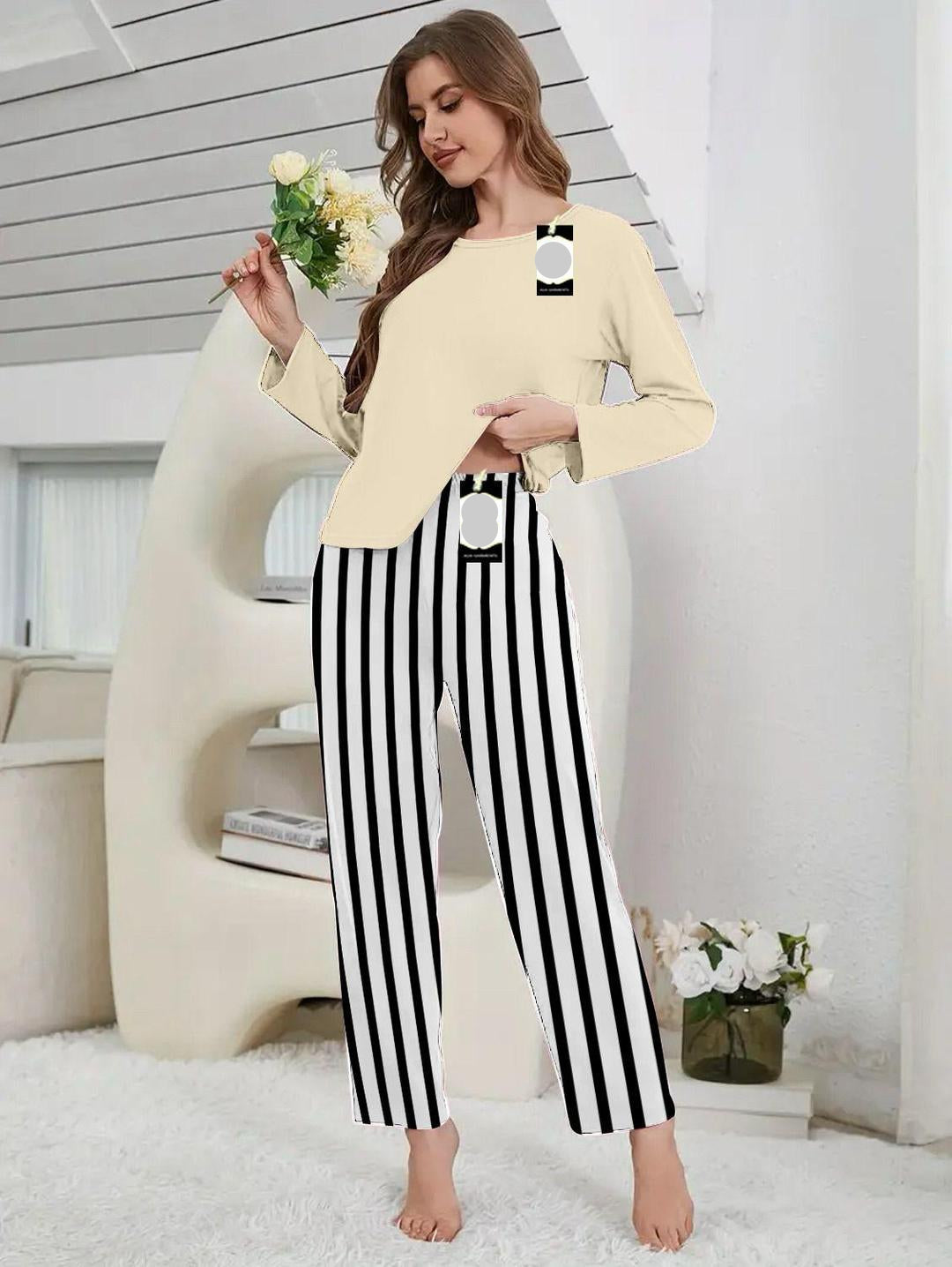 Woman wearing a beige top and black and white striped pants in a home setting.