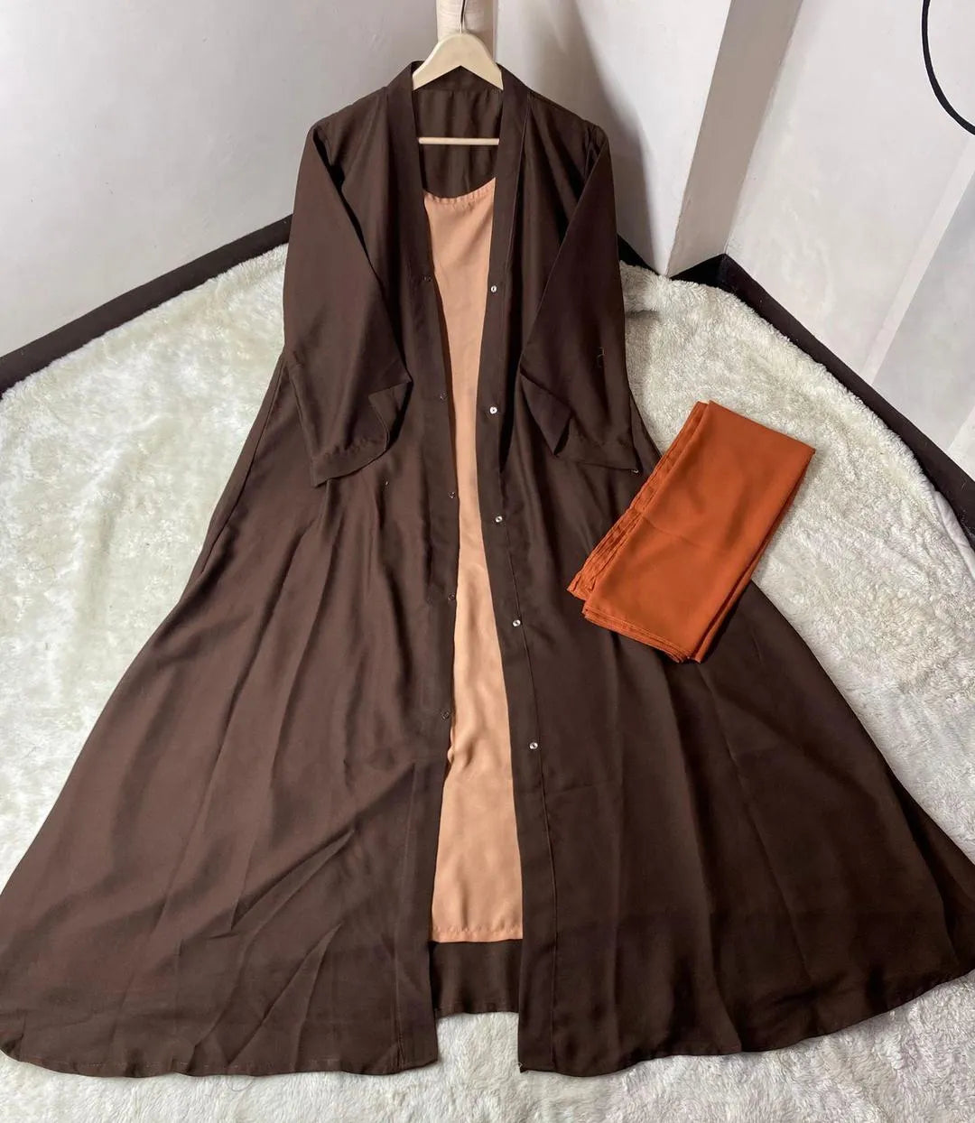 Brown dress with a beige inner lining on a white surface