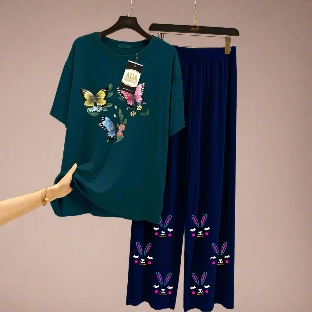 Teal t-shirt with butterfly design and navy pants with bunny face design on hangers against a neutral background.