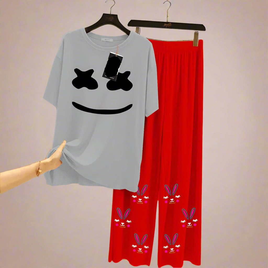 Gray t-shirt with smiley face design and red pants with bunny designs on a hanger.