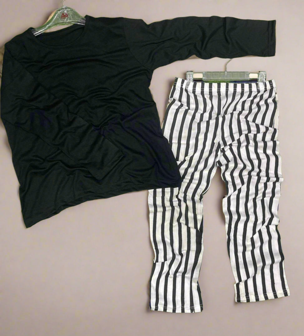 Black long-sleeve top and black and white striped pants on a beige background